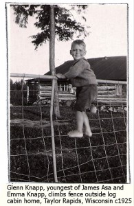 Glenn Knapp climbing fence around old log cabin homestead, Taylor Rapids, Wisconson c 1925