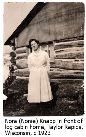 Nora Knapp in front of log cabin home in Taylor Rapids, Wisconsin, 1923