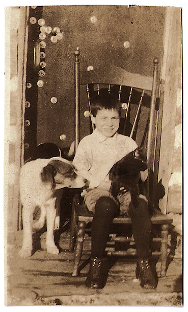 Wayne Knapp in chair next to dog, Taylor Rapids, Wisconsin, circa 1920